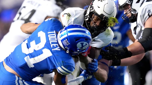 Cincinnati Bearcats running back Corey Kiner (21) is tackled by Brigham Young Cougars linebacker Max Tooley (31) in the third quarter during a college football game between the Brigham Young Cougars and Cincinnati Bearcats